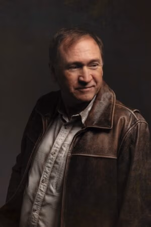 Image of DC Scott wearing leather jacket looking to right